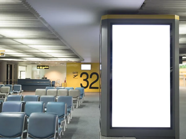 Airport advertising board sign concept : Big blank white advertising billboard screen frame at the airport with copy space in public place , passenger waiting seat and airport gate number background — Stock Photo, Image