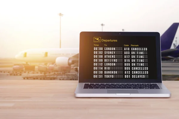 Технологія комфортного подорожі, туристична, туристична концепція: статус польоту на ноутбуці, ноутбук з аеропортом та розмитим фоном літака, ефект плівки. Зареєструйтеся онлайн. Перевірити статус рейсу онлайн . — стокове фото