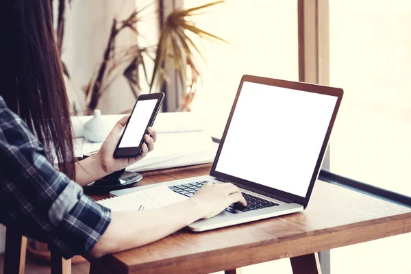 Jonge Aziatische vrouw freelance met behulp van smartphone en notebook computer thuis werken.Girl browsing internet, chatten, bloggen. Vrouwelijke telefoon vasthouden en op zoek naar blanco wit scherm, anoniem gezicht. — Stockfoto