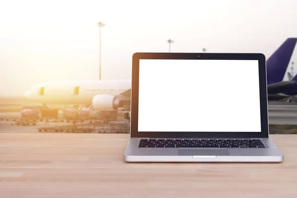 Tecnologia per un viaggio confortevole, turistico, concetto di viaggiatore: schermo bianco vuoto su notebook, laptop con aeroporto e sfocatura sfondo aereo, effetto film . — Foto Stock