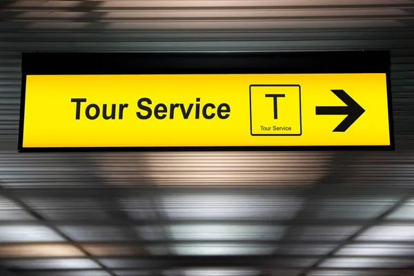 Señal de servicio de tour en el aeropuerto con flecha para la dirección de servicio de contador de turismo para el turista — Foto de Stock