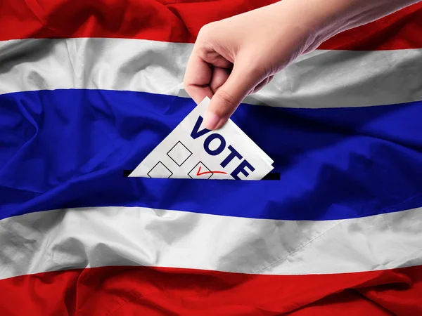 Demokratie und Wahlen im thailändischen Konzept. Nahaufnahme einer Person, die einen Stimmzettel bei Wahlen während der Stimmabgabe auf Leinwand im Hintergrund der thailändischen Flagge abgibt. — Stockfoto