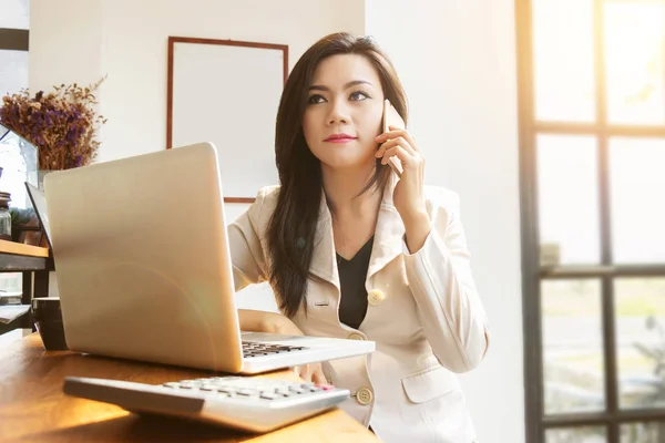 Retrato de mujer de negocios asiática hermosa y confiada en edad de trabajar utilizando la tecnología de computadora portátil y teléfono inteligente para administrar el trabajo. mujer de negocios, poder femenino y Día Internacional de la Mujer —  Fotos de Stock