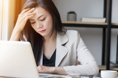 İşteki genç Asyalı kadın, ofisteki depresyondaki kadın. Güzel Asya 'lı genç bir kadının portresi hasta, başı ağrıyor, ofis sendromu yaşıyor. İş yerindeki sağlık hizmetleri kavramı