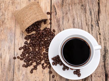 ahşap masada kahve çekirdeği ile taze espresso kahve fincanı. kafe veya kafe için kahve arka plan
