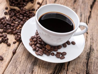 ahşap masada kahve çekirdeği ile taze espresso kahve fincanı. kafe veya kafe için kahve arka plan