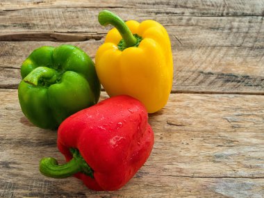 taze yeşil , ahşap arka plan üzerinde kırmızı ve sarı biber. baharat sebze