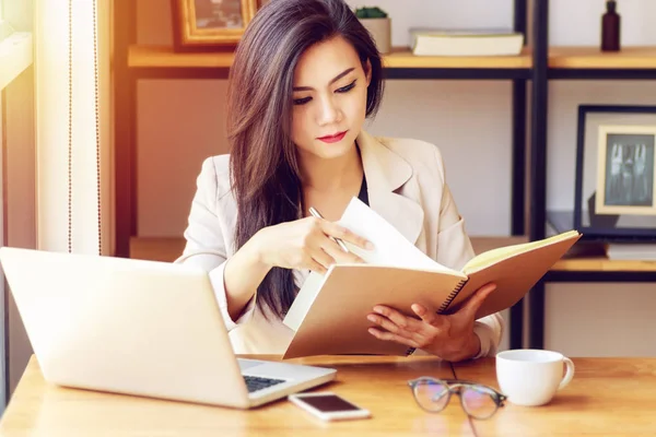 Joven mujer de negocios asiática que trabaja en el lugar de trabajo. hermosa mujer asiática en traje casual trabajando con libro de lectura, prepararse para la reunión o entrevista en la oficina moderna. freelance, start-up business en Asia —  Fotos de Stock