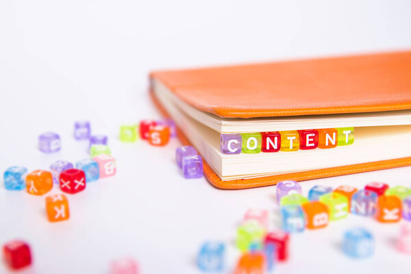 CONTENT word on colorful bead block as bookmark in book. content marketing idea concept