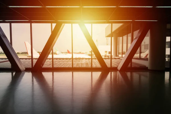 Vista del estacionamiento del avión en la puerta del puente camino a pie entre la terminal en el aeropuerto con efecto de luz, fondo para el viaje y el concepto de vacaciones —  Fotos de Stock