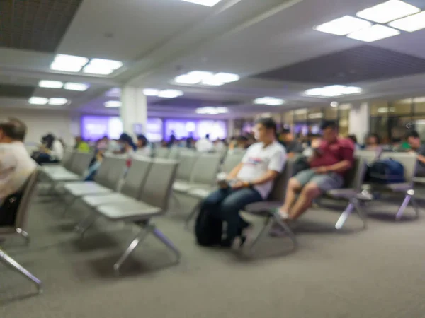 Desenfoque abstracto de los pasajeros que se sientan en la puerta del aeropuerto para esperar la hora de embarque —  Fotos de Stock
