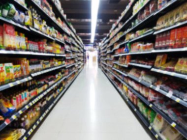 arka plan için kasiyer bulanık müşteri ile raflarda renkli mallar ile soyut bulanık süpermarket koridoru