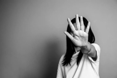 Kadın, caydırmak için elini kaldırdı. Kampanya, kadınlara yönelik şiddeti durdurdu. Asyalı kadın, siyah-beyaz fotokopi almaktan caymak için elini kaldırdı.