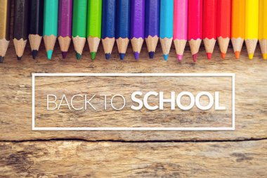 beyaz kenarlık lı okula metin ile eski ahşap arka plan masada renkli renkli kalemler