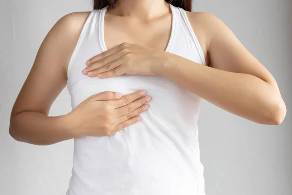Γυναίκα με λευκό γιλέκο χρησιμοποιεί το χέρι της για αυτοέλεγχο του καρκίνου του μαστού. υγιεινή γυναίκα lifestyle ιατρική αντίληψη — Φωτογραφία Αρχείου