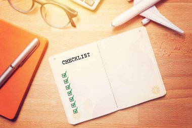 seyahat kontrol listesi kavramı. gözlük ve uçak modeli ile ahşap arka plan üzerinde boş kontrol listesi ile dizüstü bilgisayar