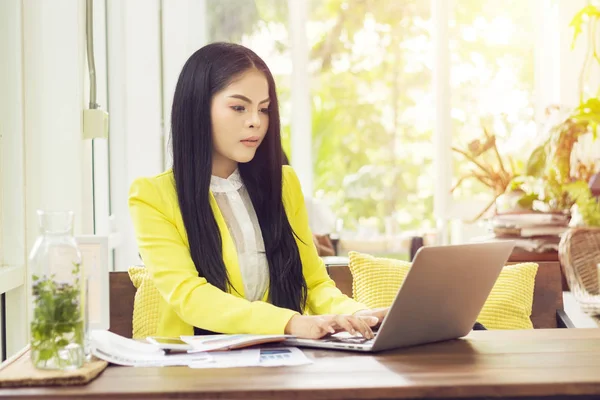 Jong mooi aziatisch zakenvrouw zitten aan tafel in koffie winkel werken met laptop — Stockfoto