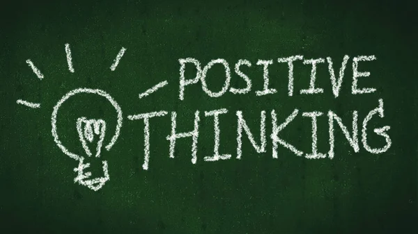 positive thinking concept. handwritten word positive thinking on black chalkboard with light bulb as idea