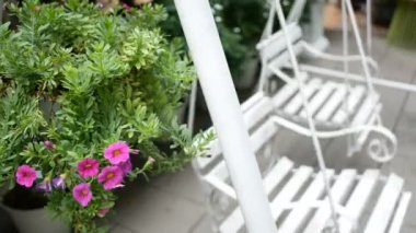 4k. iki boş beyaz salıncak dinlenmek için güzel pembe çiçekler ile yeşil bir bahçede sallanan