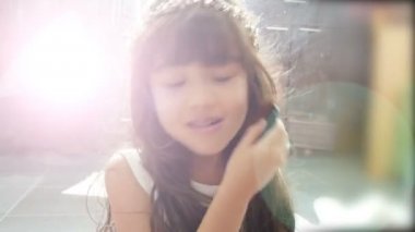 sevimli küçük kız giyinme ve evde makyaj ile oynuyor. elmacık kemikleri yüzünde büyük bir fırça ile kozmetik uygulayan kız. neşeli çocukluk, sevimli gülümseyerek. genç kız için mutlu anlar.