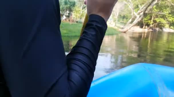 男はゴムボートに座り 川の下で漕ぐパドルを取る — ストック動画