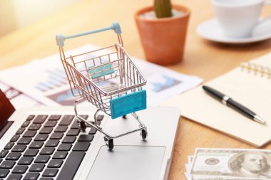 E-ticaret iş konsepti. pazarlama grafik ve para nakit notu ile dizüstü bilgisayar klavyesi üzerinde alışveriş sepeti. internet teknolojisi, pazarlama stratejisi ile online alışveriş ve işlem.