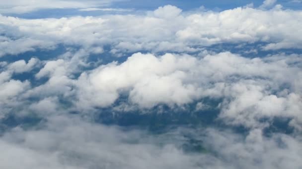 4K. vue aérienne à travers une fenêtre d'avion. beaux nuages blancs en fond de ciel bleu. voyager par avion .