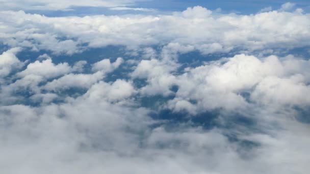 4K. vue aérienne à travers une fenêtre d'avion. beaux nuages blancs en fond de ciel bleu. voyager par avion .