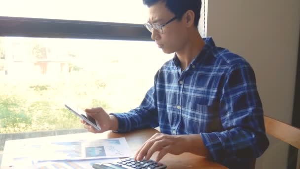 Кадры Серьезный Азиатский Бизнесмен Работающий Бумажной Работой Калькулятором Расчета Документов — стоковое видео