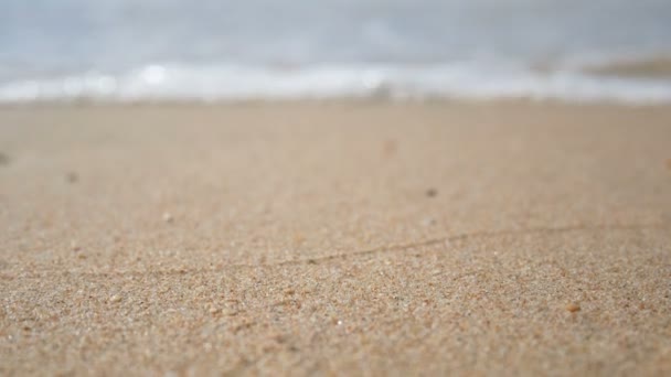 4K. vague douce de la mer, se concentrer sur le sable .eau claire sur la plage de sable blanc avec espace de copie. plage tropicale d'été de mer pour des images de fond de vacances 
