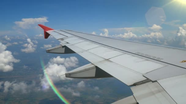 4K映像 飛行機で旅行する レンズフレアからの光と飛行機の窓を通して空中ビュー 背景のための青空の翼飛行機と美しい白い雲 — ストック動画