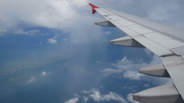 4K映像 虹の上を飛び越える飛行機の窓から空中ビュー 旅行の背景のための青空の翼飛行機と美しい白い雲 飛行機で旅行する — ストック動画