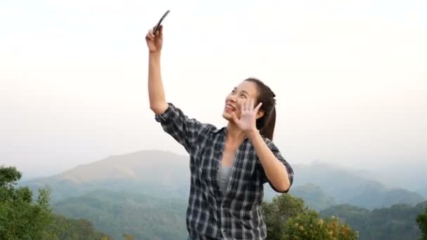 美丽的亚洲妇女视频聊天使用智能手机户外分享旅游自然视图与朋友或通过社交媒体直播 — 图库视频影像