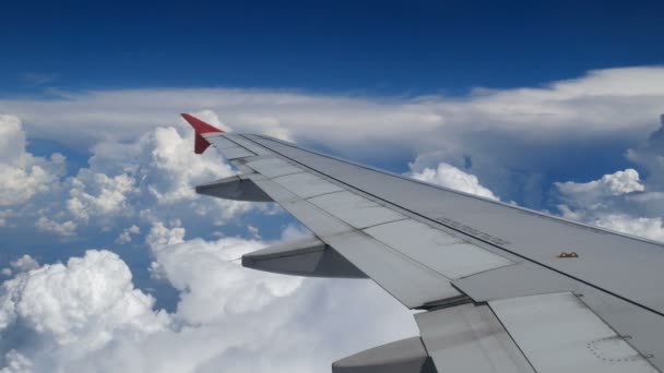 映像飛行機 白い雲と青い空上空を飛んでいる飛行機の翼 航空機によって所要時間に飛行機の窓から美しい撮 — ストック動画
