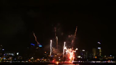 Arka planda şehir manzarası ile gece kutlama için gökyüzünde gerçek havai fişek festivali 4k görüntüleri. renkli fişek gece kutlamak