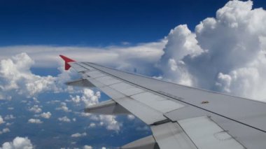 4 k görüntüleri uçak uçuş. beyaz bulutlar ve mavi gökyüzü üzerinde uçan bir uçağın kanat. zaman uçak ile seyahat güzel havadan görünümü uçağın penceresinden. tatil, tatil zamanı