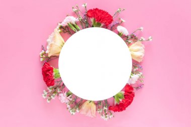 beyaz daire afiş etiketi ile parlak pembe arka planda taze renkli bahar çiçekleri ile yapılan yaratıcı düzeni. düğün daveti, poster veya tebrik tasarımı