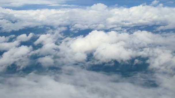 4K. vue aérienne à travers une fenêtre d'avion. beaux nuages blancs en fond de ciel bleu. voyager par avion .