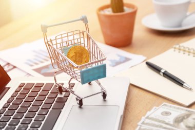 Online ticaret kavramı üzerinden döviz yatırım Bitcoin. çalışma alanında dizüstü bilgisayar klavyesi üzerinde sepette altın Bitcoin