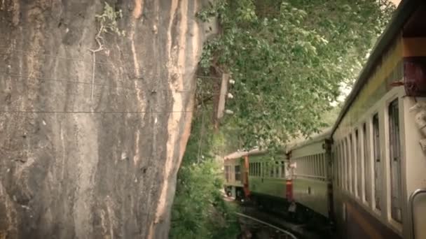 4K镜头的古代列车运行在锋利的弧形铁轨弯曲到横跨桂河的一座桥上 电影彩色滤光片效果 外国游客在泰国的热门景点 — 图库视频影像