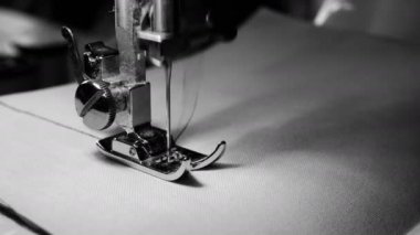 4k görüntüleri. yavaş hareket, siyah ve beyaz renk ile beyaz kumaş üzerinde dikiş makinesi iğne yakın