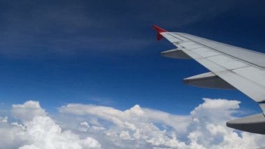 4 k görüntüleri uçak uçuş. beyaz bulutlar ve mavi gökyüzü üzerinde uçan bir uçağın kanat. zaman uçak ile seyahat güzel havadan görünümü uçağın penceresinden. tatil, tatil zamanı