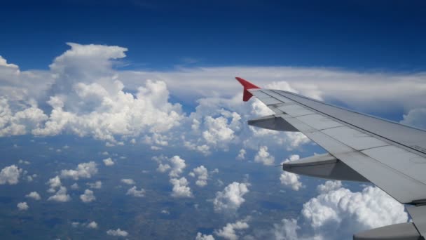 映像飛行機 白い雲と青い空上空を飛んでいる飛行機の翼 航空機によって所要時間に飛行機の窓から美しい撮 — ストック動画