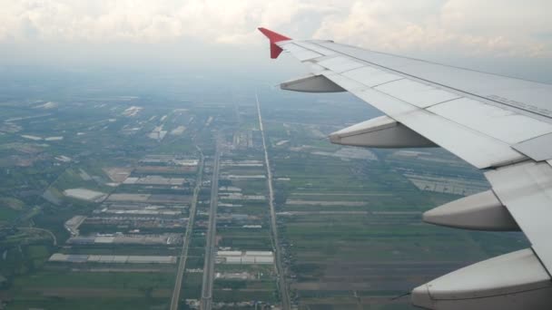 4K映像 飛行機で旅行する 着陸時に飛行機の窓を通して空中ビュー 低いレベルの方向と水田との素朴な眺めに変更のために移動翼飛行機 — ストック動画