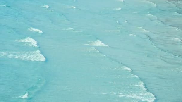 高い視点から海岸線に押しつぶされる青い泡立つ海の波の4K 熱帯ビーチ映像 — ストック動画