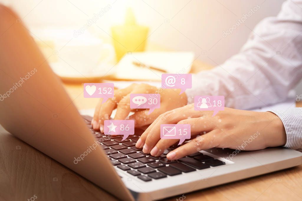 people using notebook computer laptop for social media interactions with notification icons from friend in social network with like, message, email, mention and star above smartphone screen. internet 