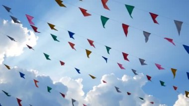 4k. renkli tasarım dekorasyon üçgen fuar bayrakları eğlenceli festival parti etkinliği için mavi gökyüzü arka plan asılı rüzgar üfleme, bayram kutlama tatil , karnaval festivali olay. 