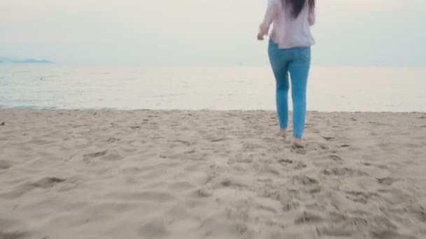 快乐的女人在热带海滩上享受暑假 赤脚跑到海边 张开双臂 摄像机平移到天空 — 图库视频影像