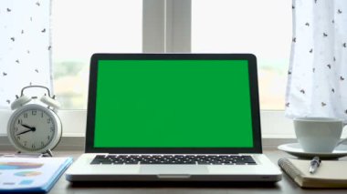 4k. beyaz perde darbe ile pencerenin yanında çalışma ofis masasına ayarlanmış yeşil ekran krom anahtar ile dizüstü bilgisayar