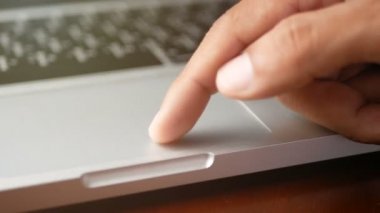 4k. Dizüstü bilgisayarla çalışan bir adamı yakın çekimde, slayt ve yakınlaştırma için klavye ve dokunmatik yüzey veya trackpad ile parmak kullanma, uzaklaştırma. 